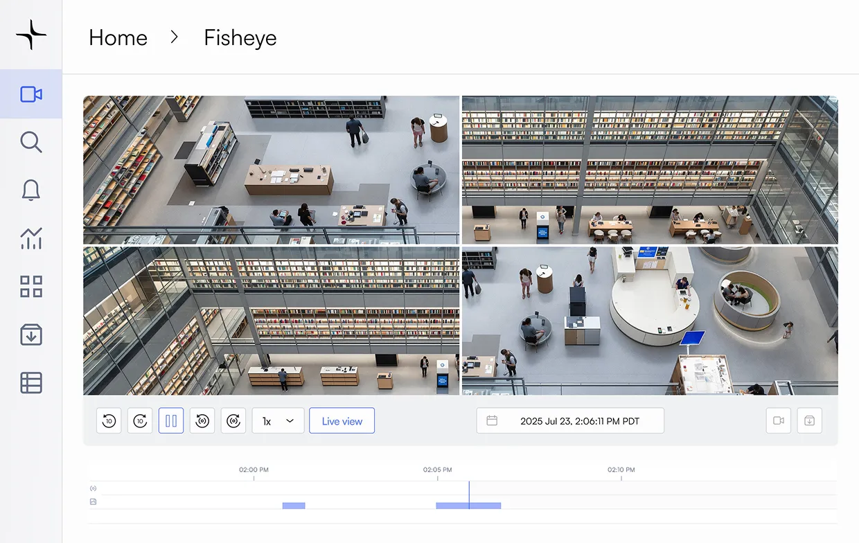 Security camera fisheye view of a modern library interior with people, bookshelves, and seating areas.