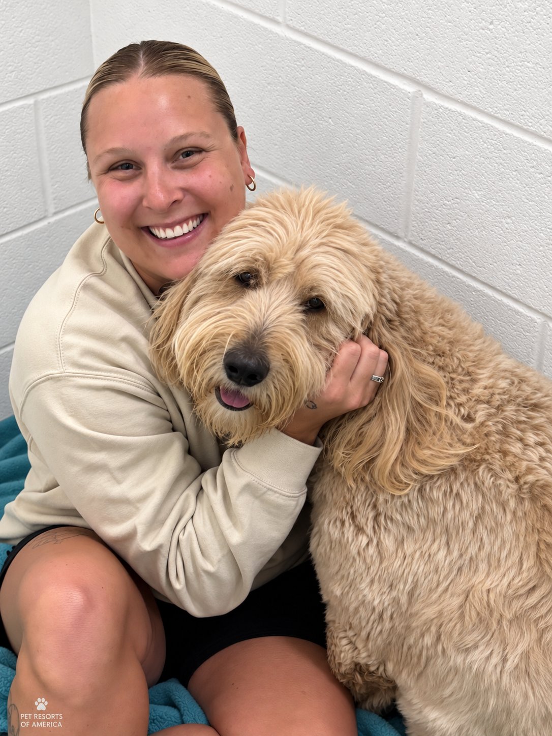 Pet Resorts of America team member hugging a boarding dog