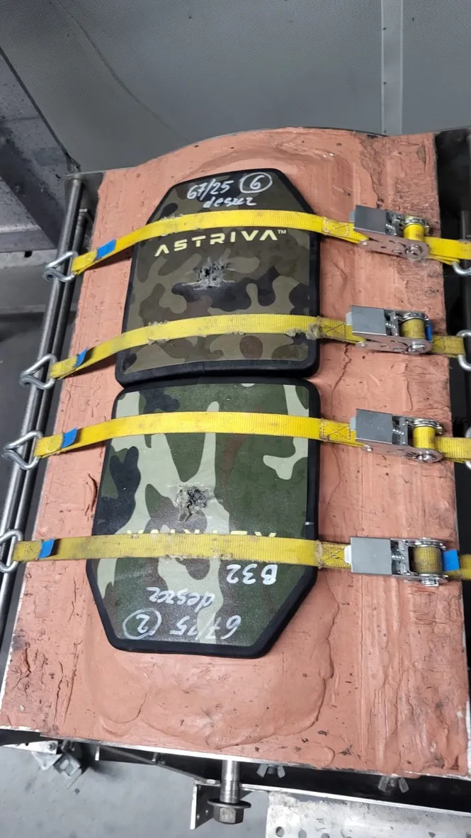 Płyty balistyczne Astriva w kamuflażu, zamocowane pasami transportowymi do bloku podłoża badawczego po przeprowadzonych testach ostrzału.