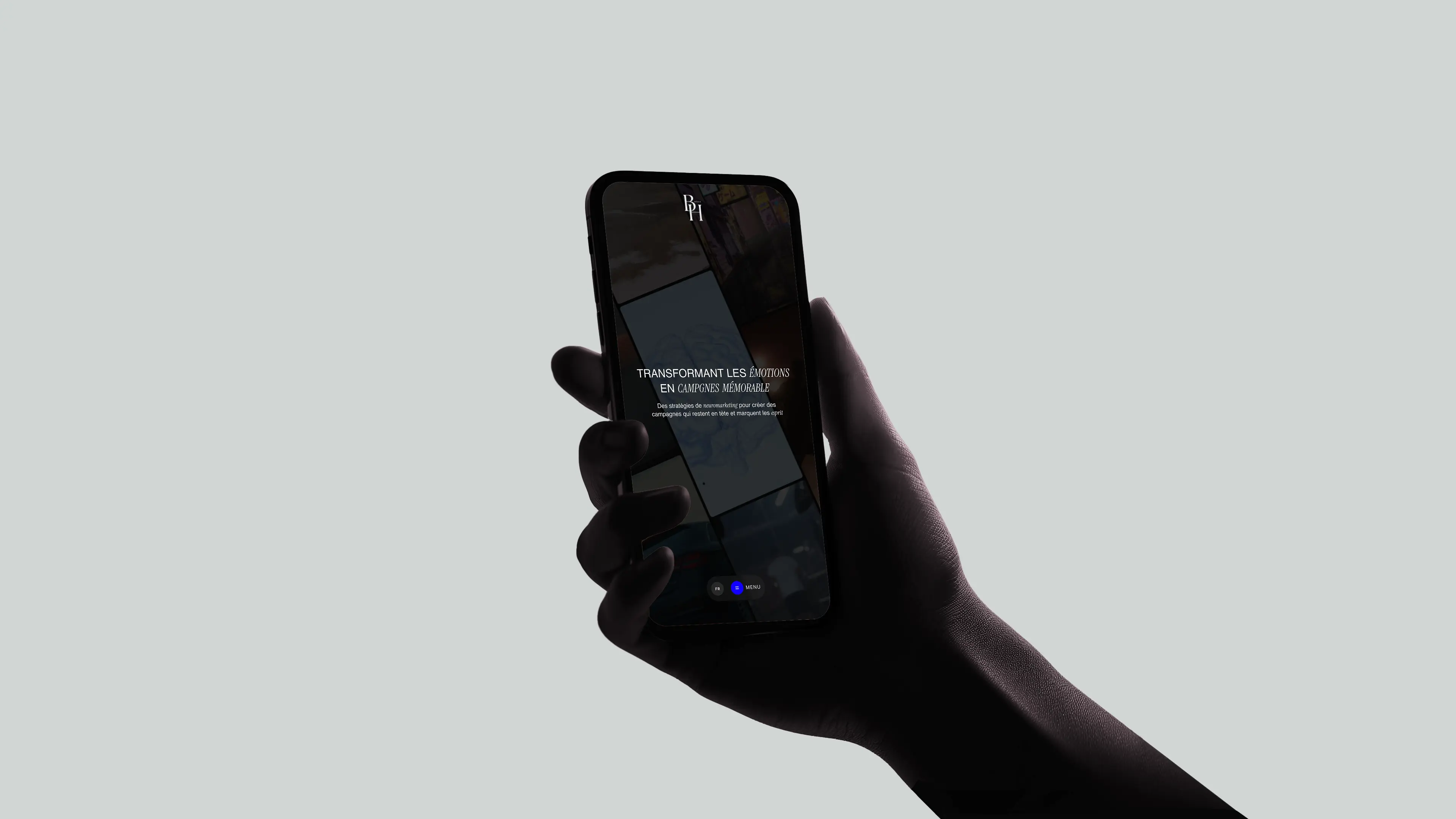 Personne tenant un téléphone sur le site de BH Media