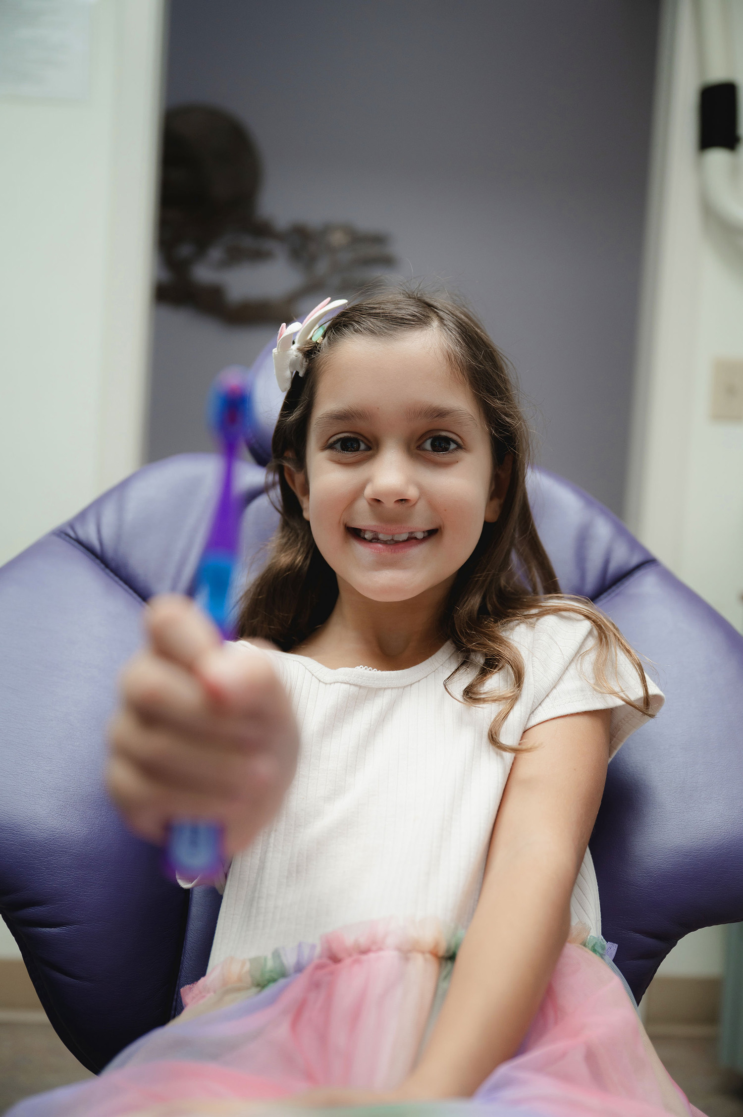 Hands holding and pointing at a dental model showing upper and lower teeth.