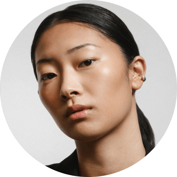 A woman with a black shirt and earrings.