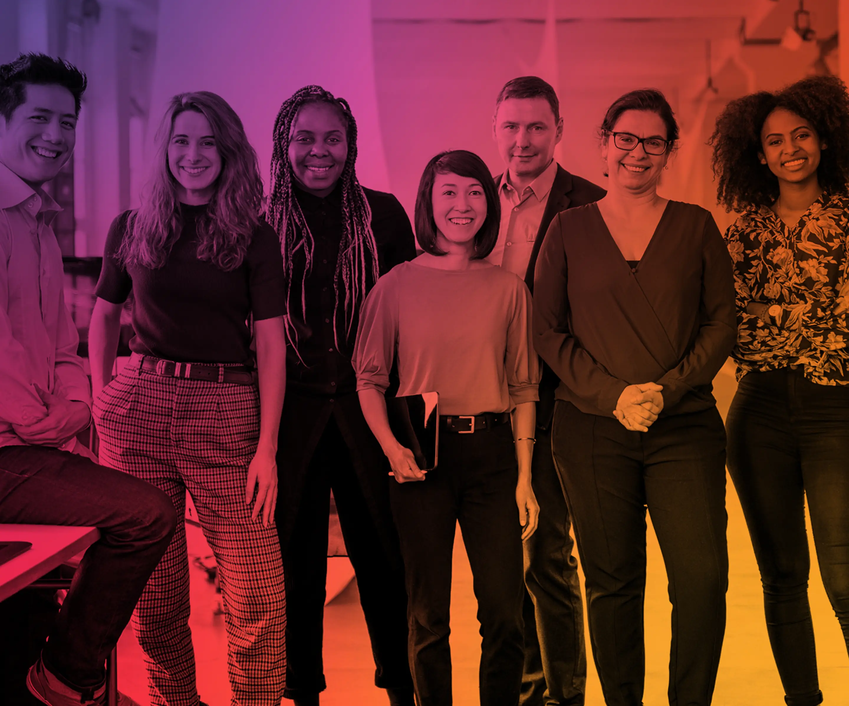 Diverse group of seven smiling professionals standing in an office with colorful gradient overlay.