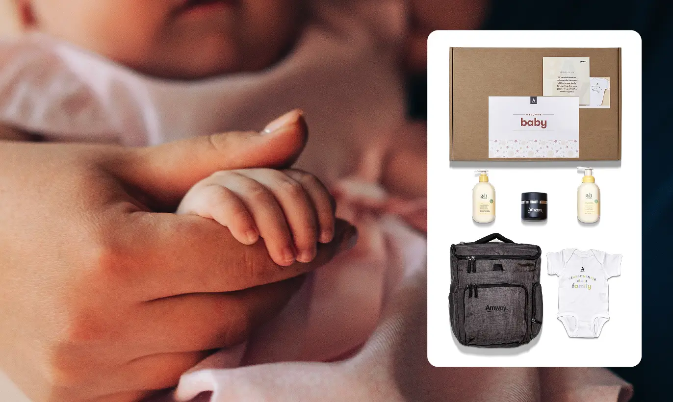 Coffret cadeau comprenant un sac à dos Amway, un body pour bébé portant l'inscription « Un nouveau membre dans notre famille », des produits de soin pour la peau et une boîte portant l'inscription « Bienvenue bébé ».