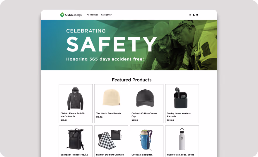 Web page from OSKOenergy celebrating safety with text 'Honoring 365 days accident free!' and a photo of two workers in safety gear, above a grid of featured products including hoodies, beanies, caps, earbuds, backpacks, blankets, and water bottles with prices.