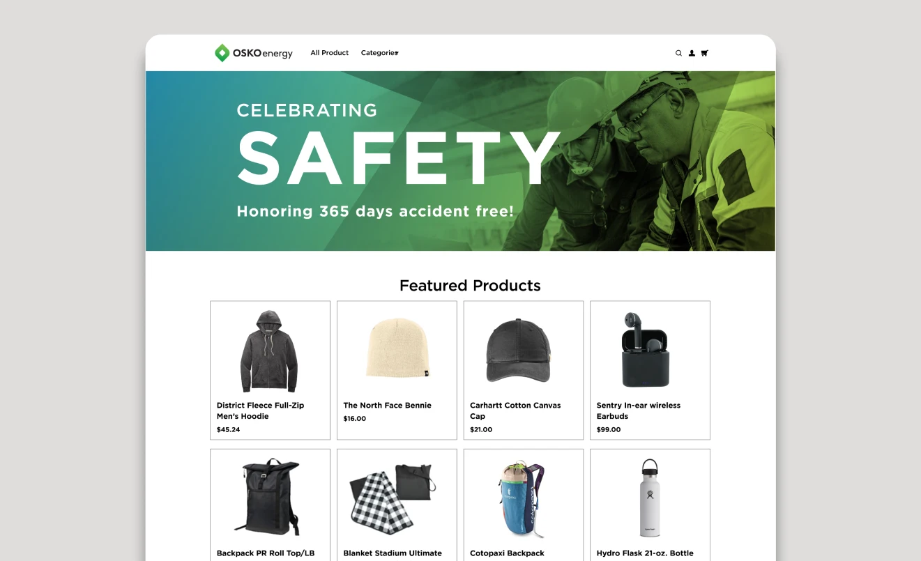 Web page from OSKOenergy celebrating safety with text 'Honoring 365 days accident free!' and a photo of two workers in safety gear, above a grid of featured products including hoodies, beanies, caps, earbuds, backpacks, blankets, and water bottles with prices.