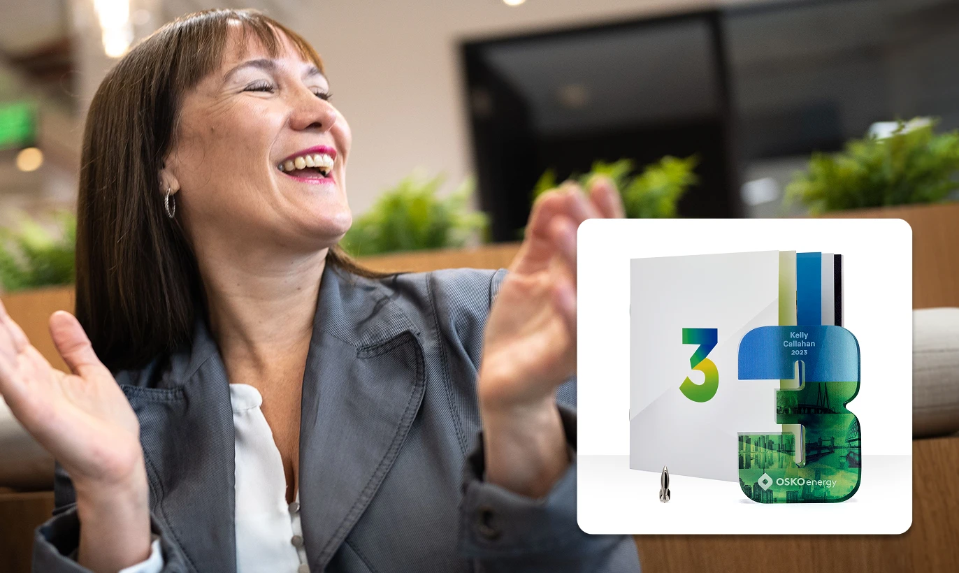 Smiling woman clapping in an office with a digital overlay of a white folder and a blue-green number 3 trophy labeled Kelly Callahan 2023 from OSKO Energy.