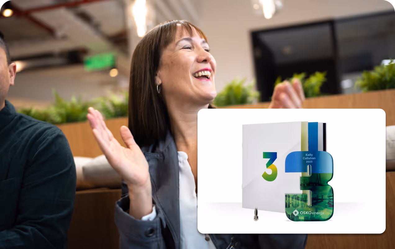 Smiling woman clapping in an office with a digital overlay of a white folder and a blue-green number 3 trophy labeled Kelly Callahan 2023 from OSKO Energy.