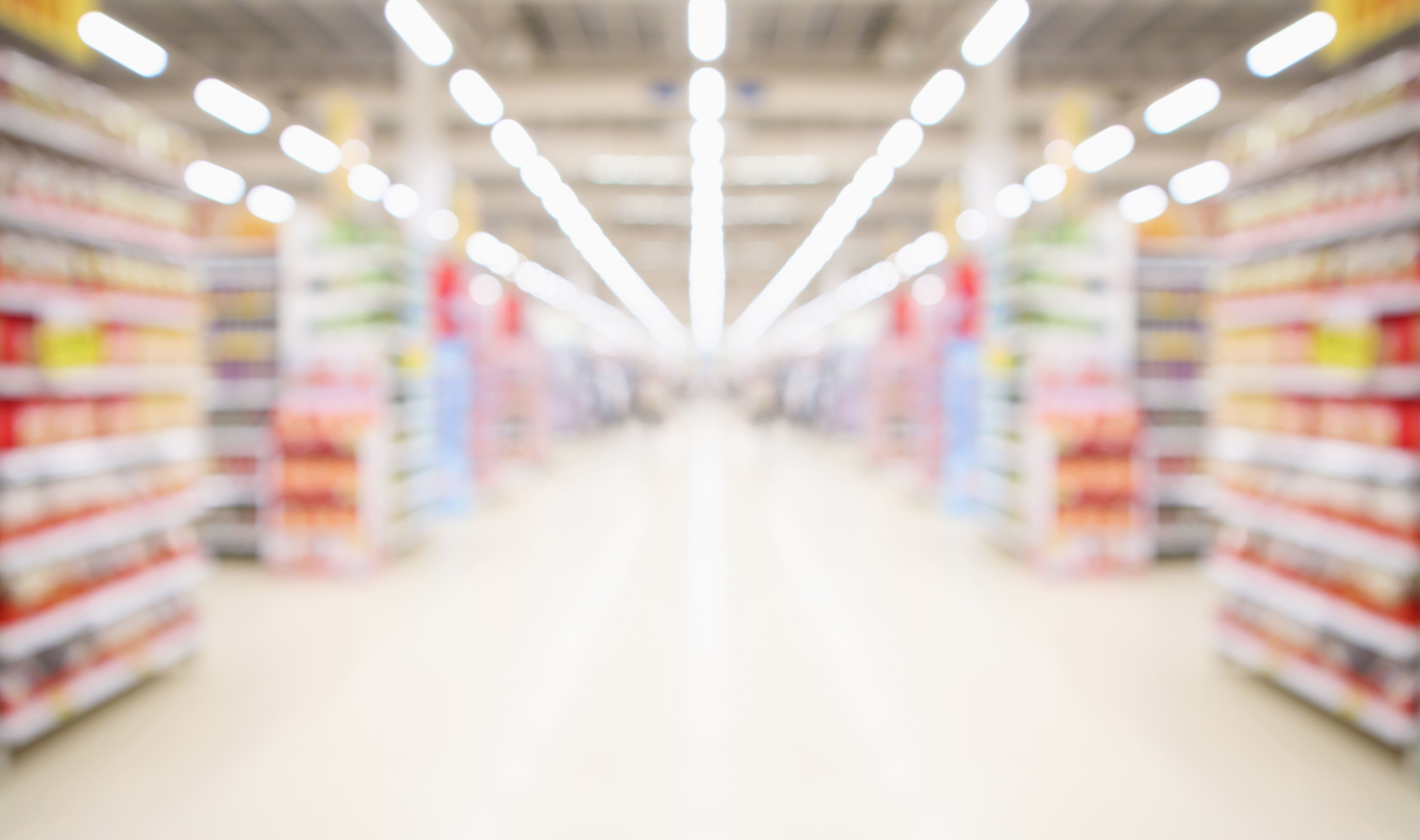 Photo of a bright grocery store lane with the aisles on both sides.