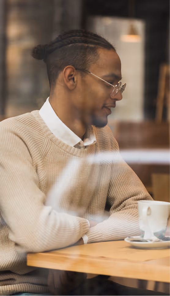 Customer enjoying a relaxed café moment with Stone Sip Roasters cold brew in a warm, modern setting.
