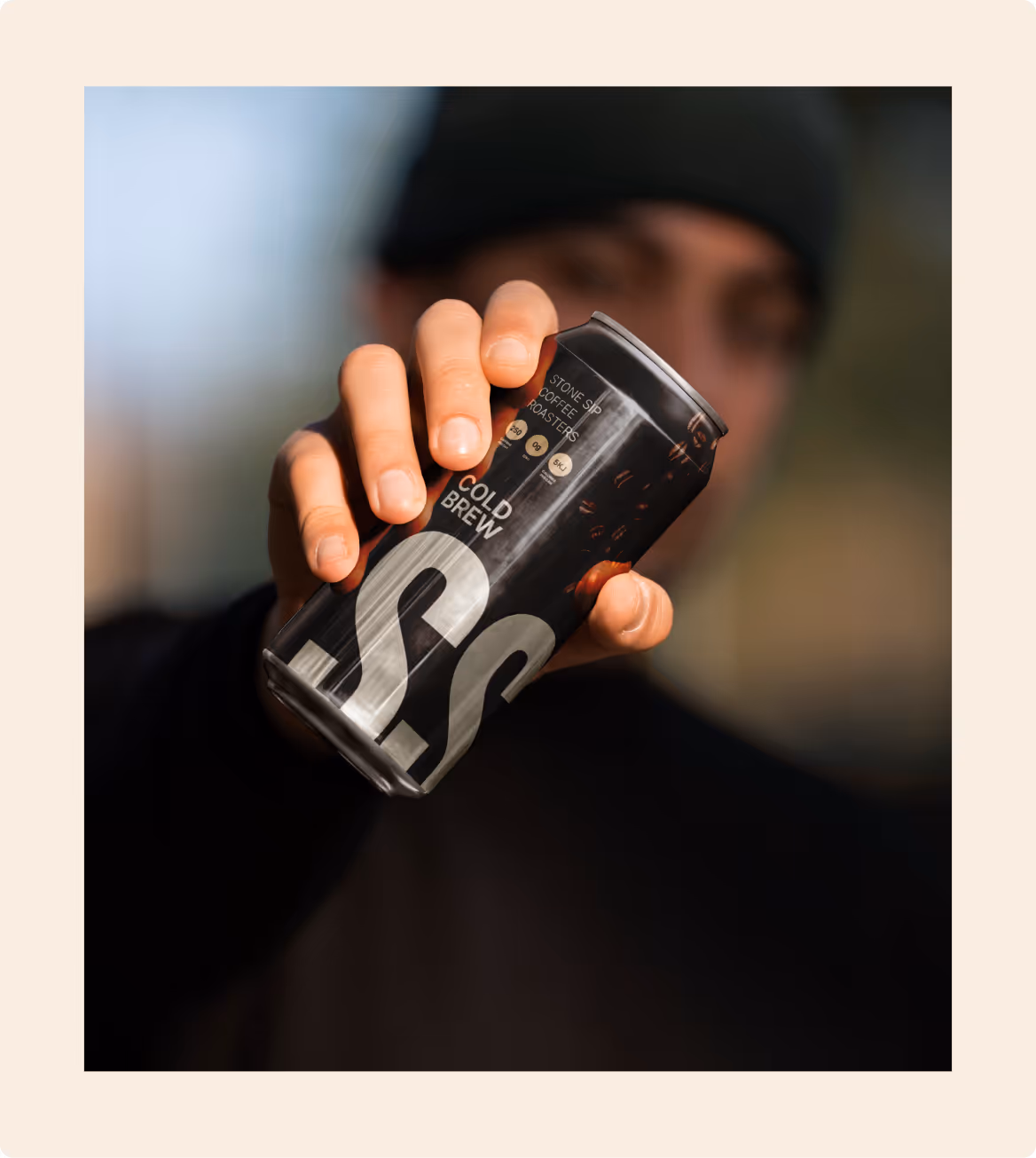 Close-up of a Stone Sip cold brew can held toward the camera, highlighting bold branding and modern coffee lifestyle.