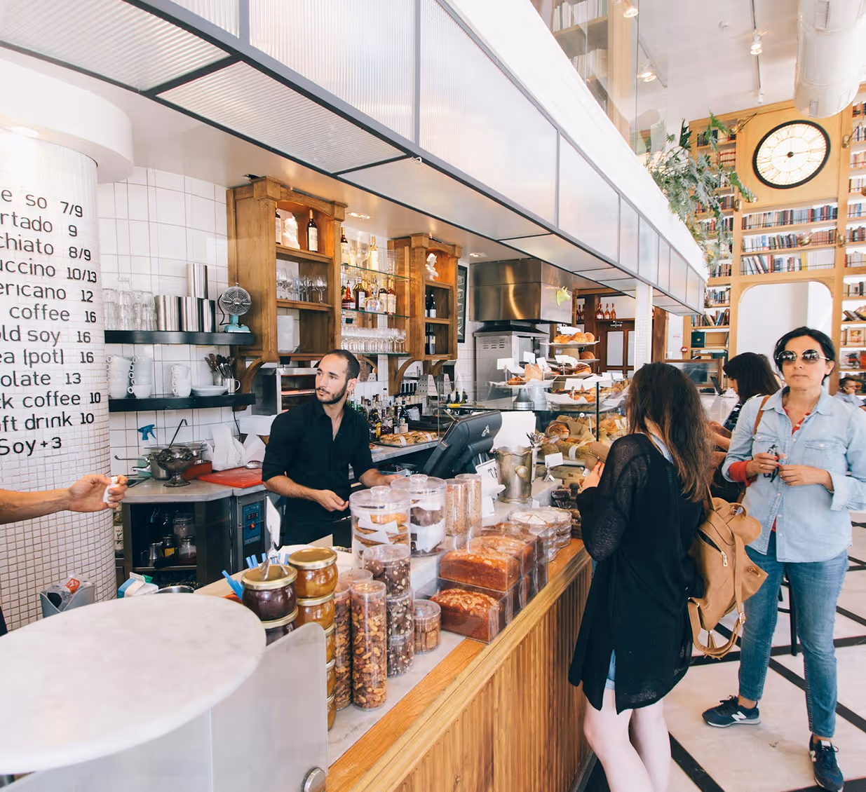 Busy coffee shop interior with customers ordering and socializing.