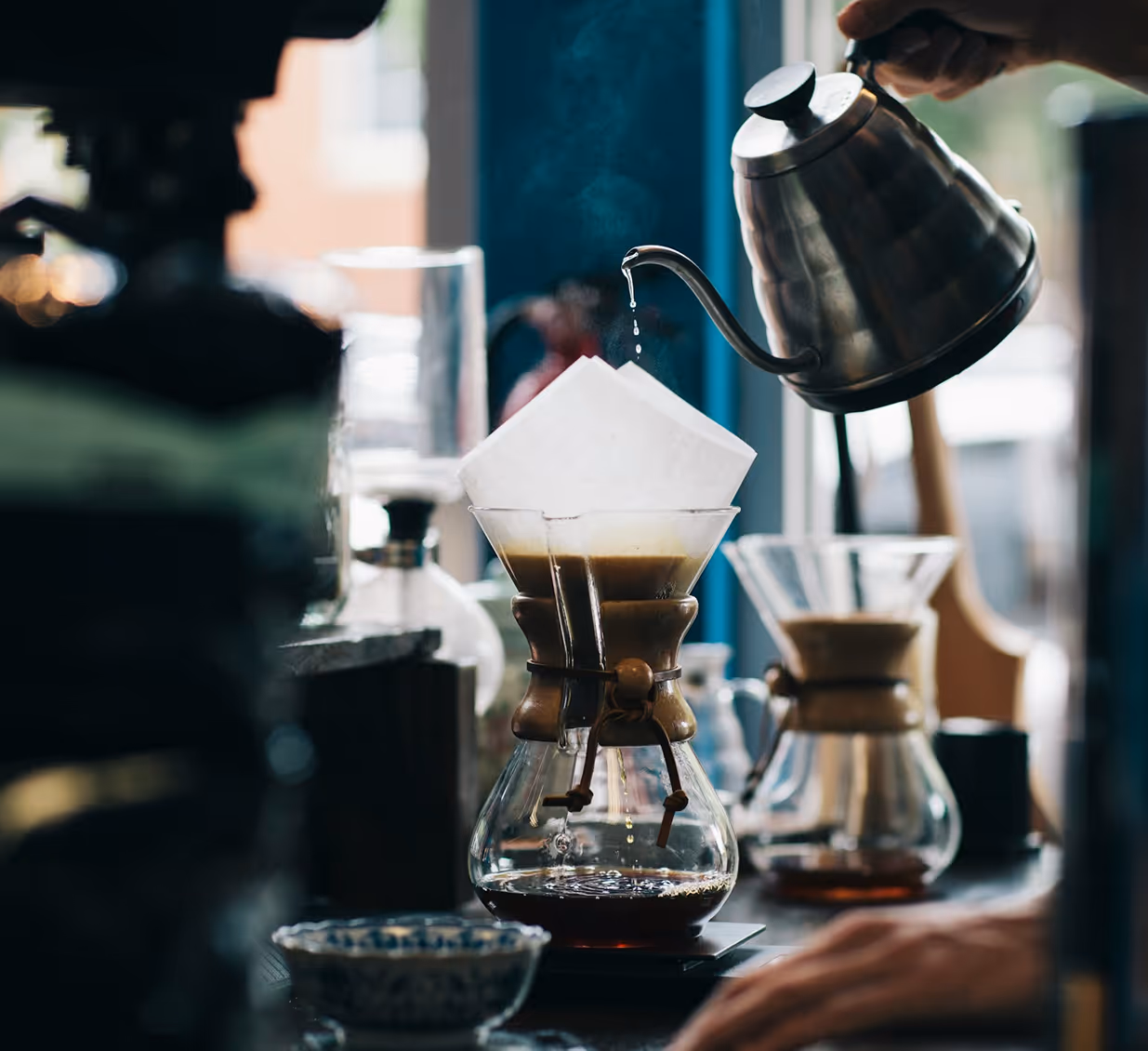 Manual pour-over coffee brewing process with fresh ground beans.