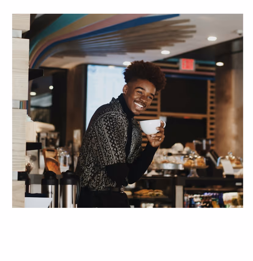 Man smiling in a coffee shop.