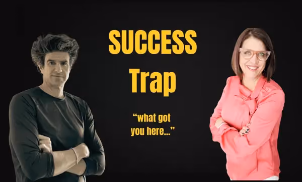 Man in black shirt and woman in pink shirt standing with arms crossed around text: Success Trap what got you here.