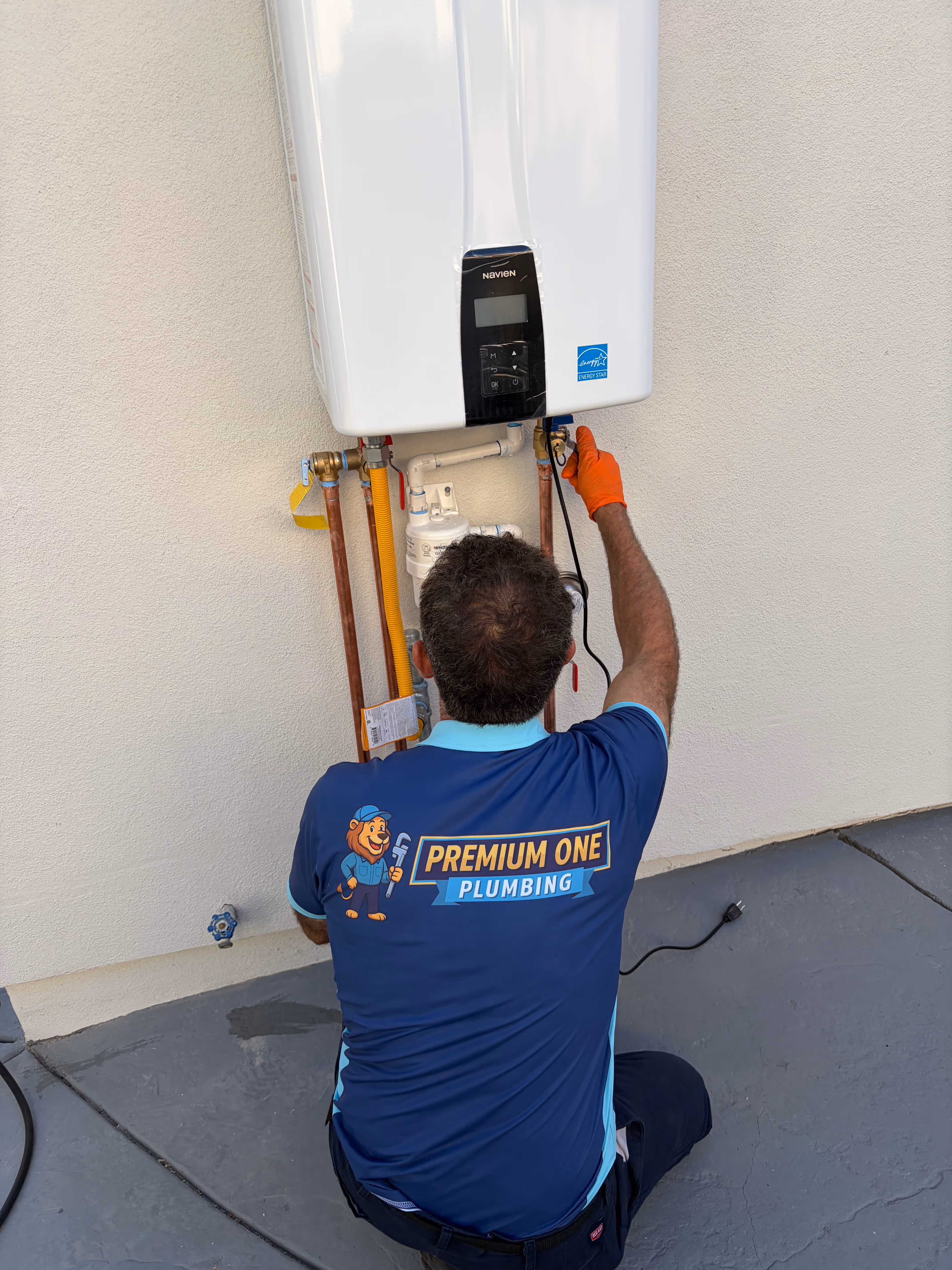 Premium One Plumbing employee installing a navien tankless water heater

