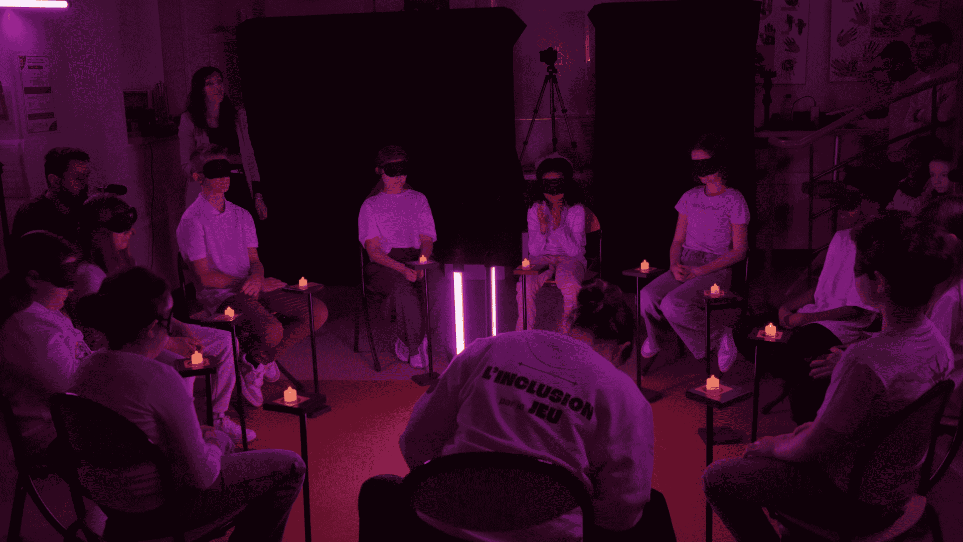 Tournage de la mini-série Le Maestro des Loups-Garous, enfants en cercle avec masques et modules du Maestro dans une ambiance lumineuse violette