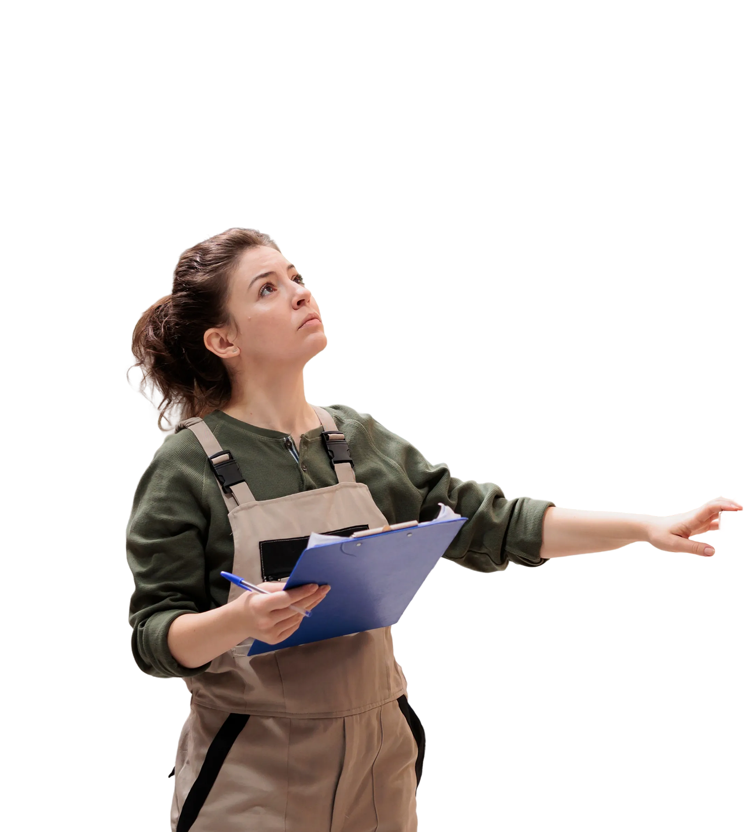 Woman in work overalls holding a clipboard and pen, looking and reaching upward with a focused expression.