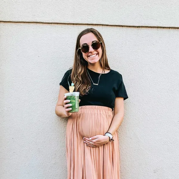 Kobieta w ciąży oparta o ścianę | Test Nifty Pro