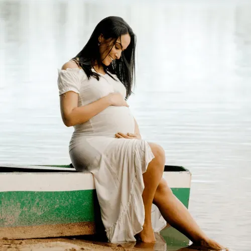 Kobieta siedzi w białej sukience w ciąży | Nifty Pro Test