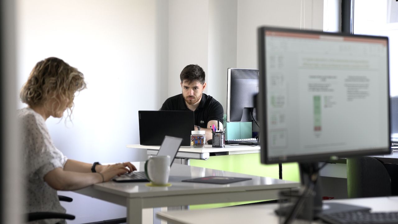 Lucen Software team members collaborating at their desks in the office