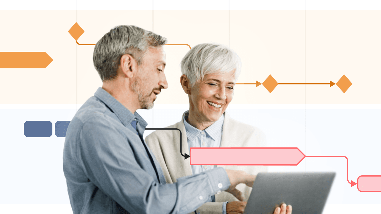 Two older adults smiling and discussing while looking at a laptop with task flow graphics.