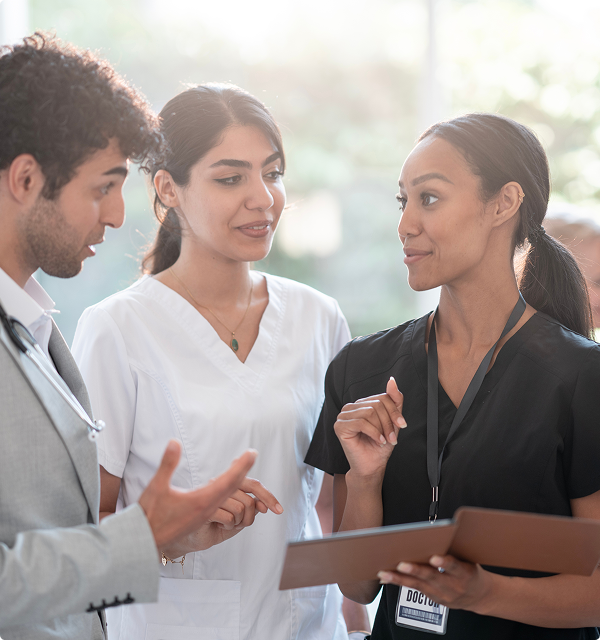 A group of diverse healthcare professionals discussing a medical file together.