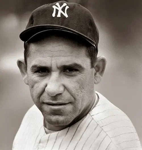 Black and white close-up portrait of a man in a New York Yankees baseball cap and pinstriped uniform.