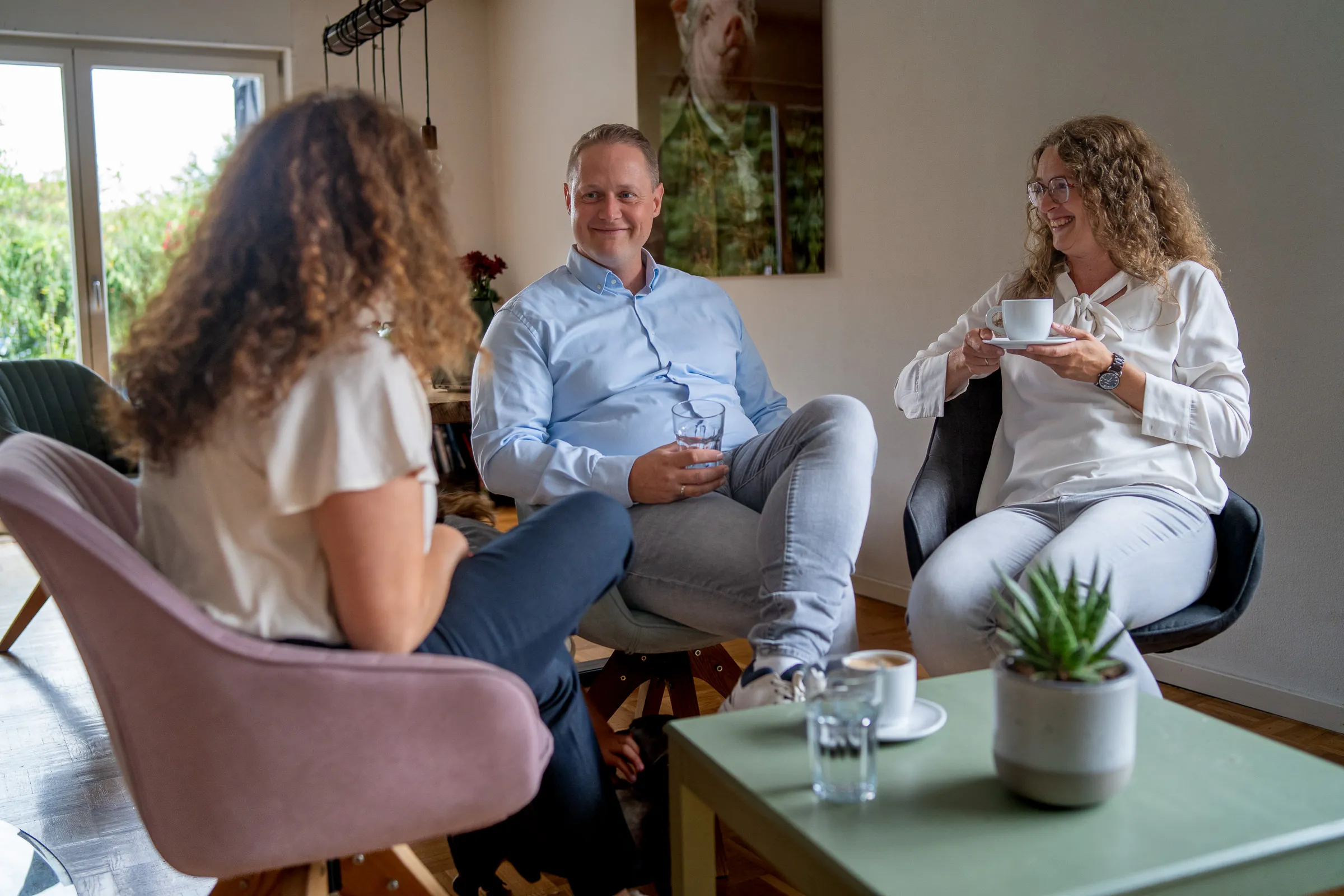Drei Personen sitzen an einem Tisch und unterhalten sich.
