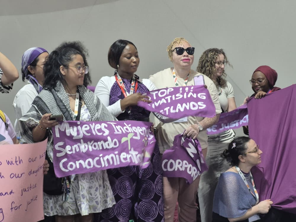 A group of women with disabilities holding posters