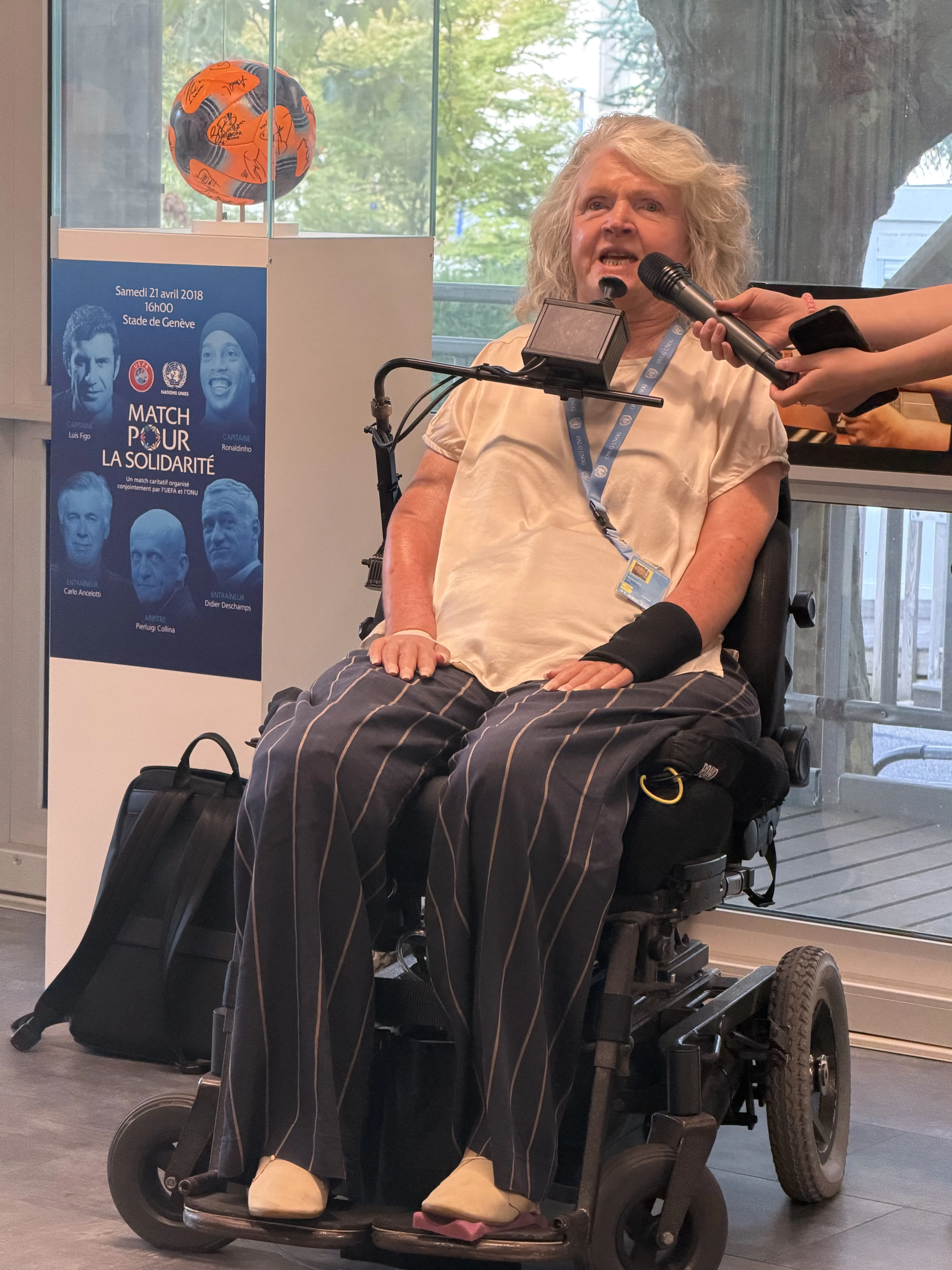 Rosemary Kayess , a wheelchair user speaking on a mic. Someone else is holding the mic for her.