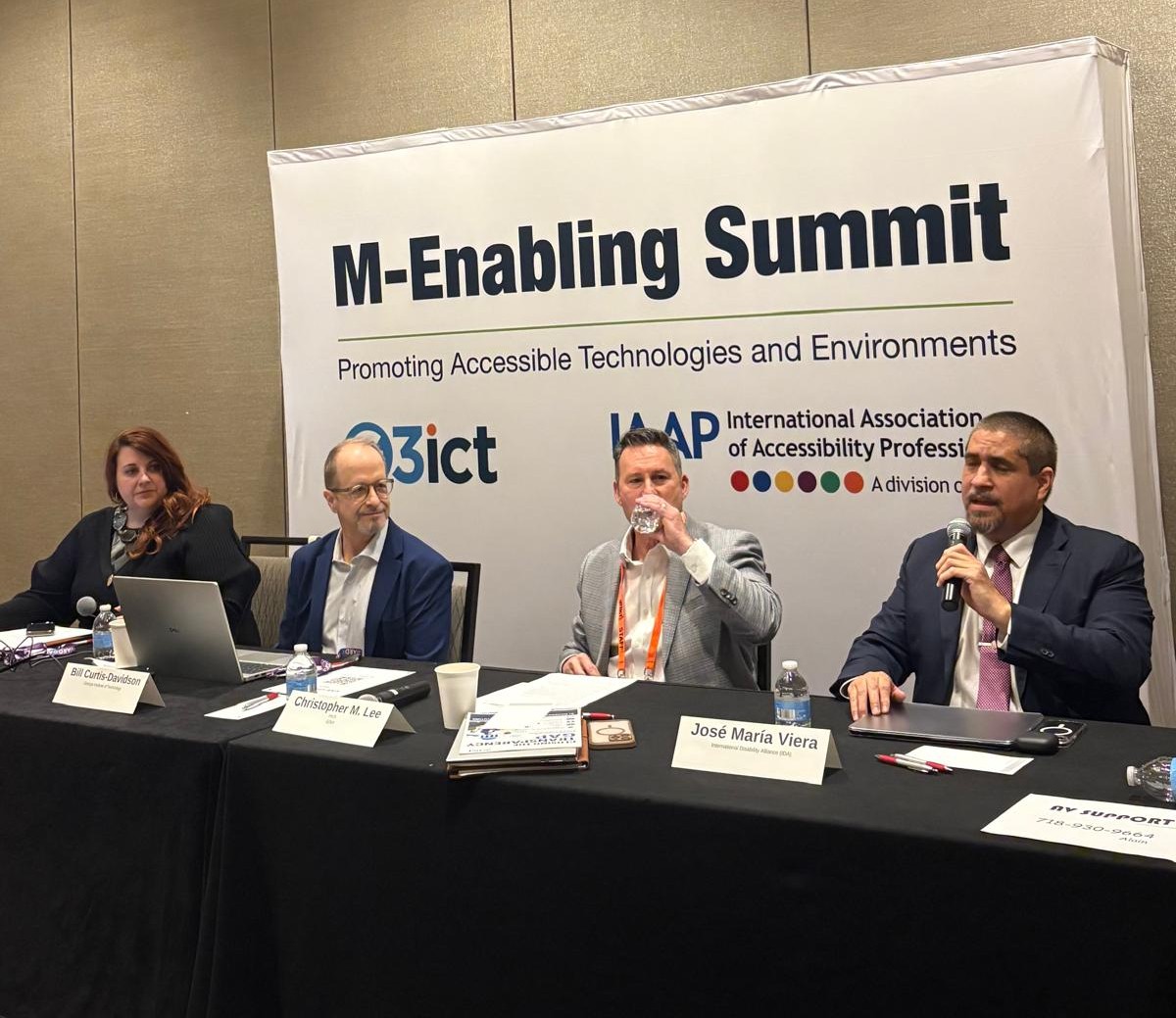 4 speakers at a panel. M-Enabling Summit. José Viera is speaking with a mic on his hand.