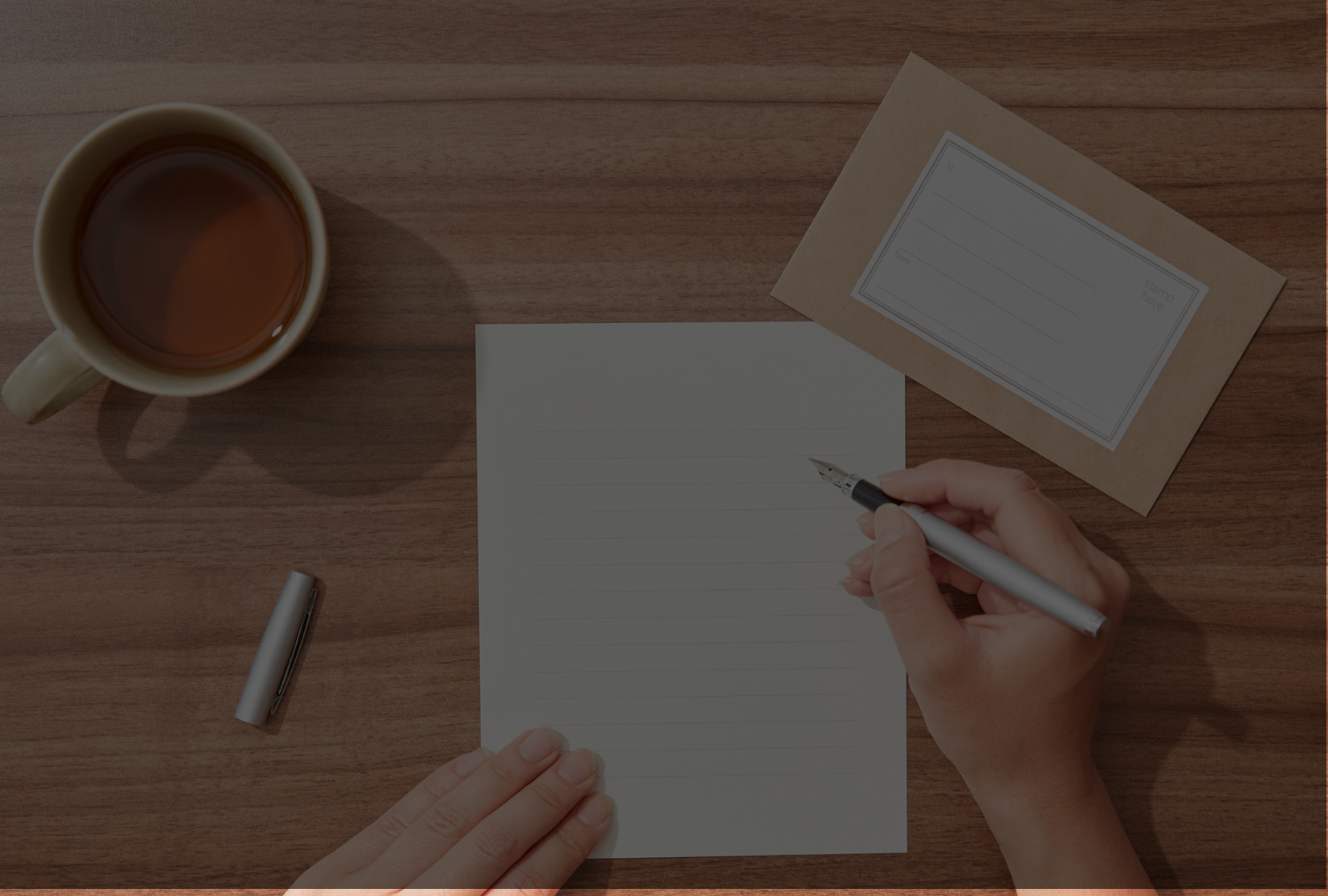 A man writing a letter from above.