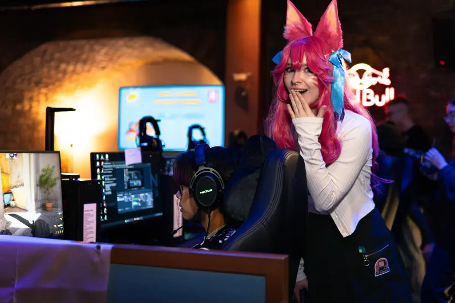Cosplayerin neben einem spielenden Gast.