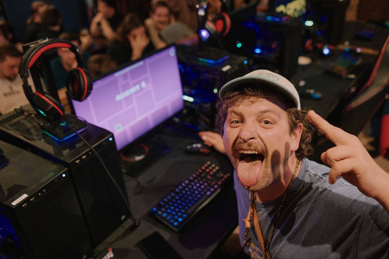 Gast posiert gut gelaunt vor einem Gaming-PC.