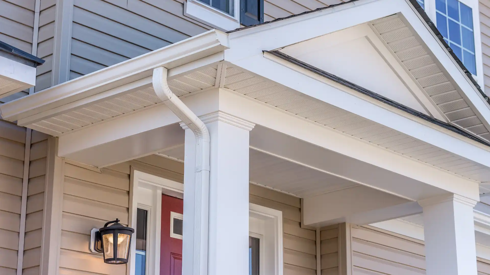 White gutter and soffit system installed over a covered front porch
