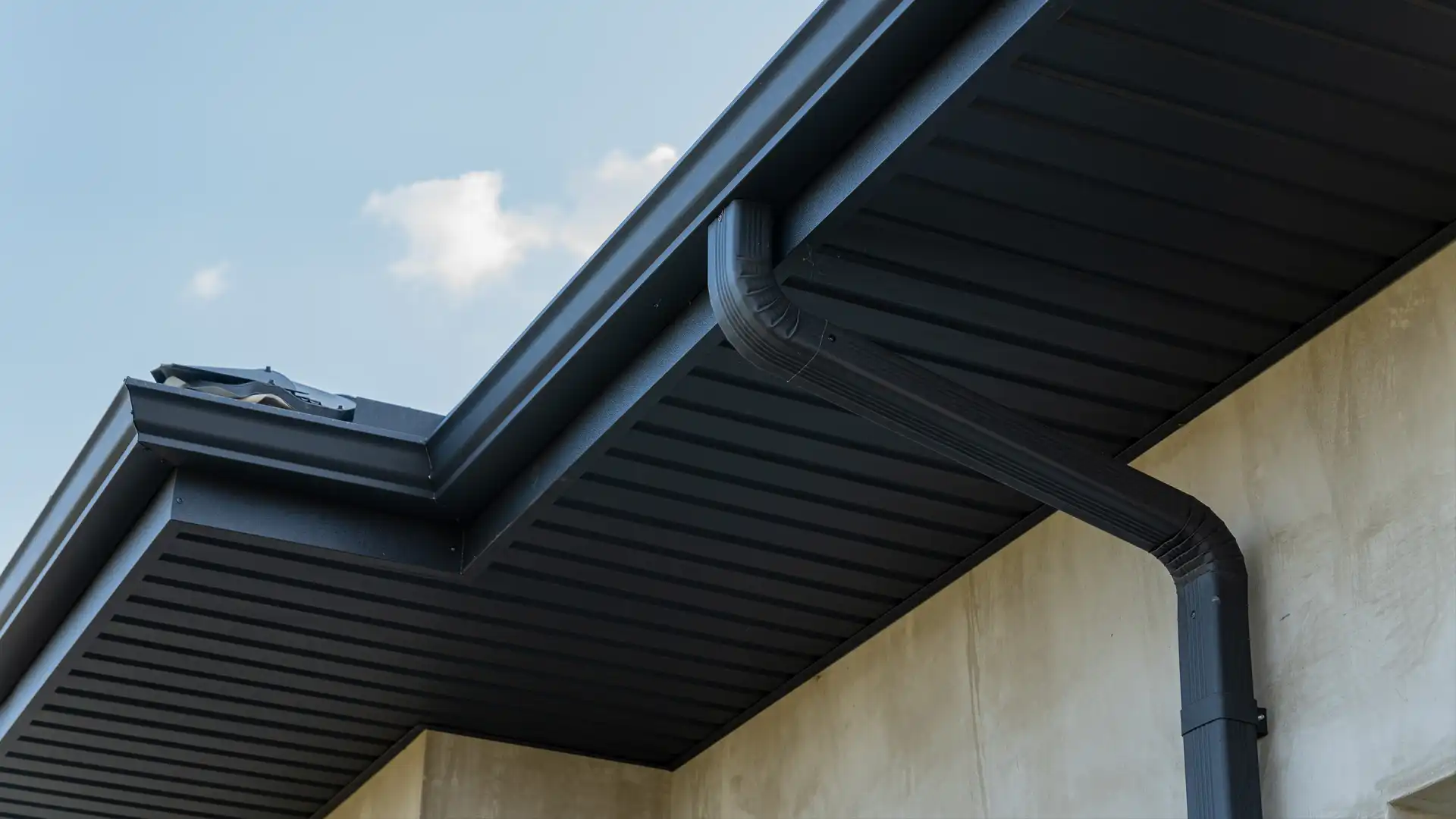 Black soffit and gutter system installed on a modern home exterior