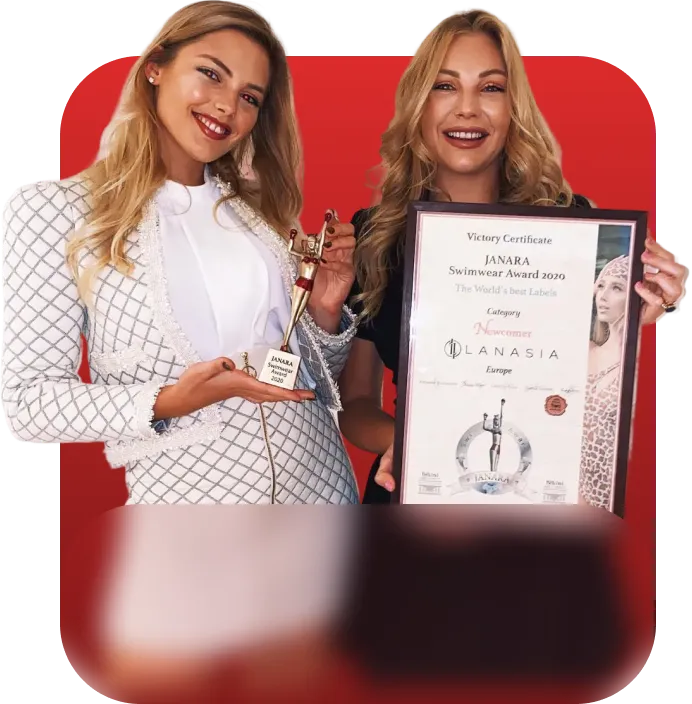 Zwei lächelnde Frauen, eine hält eine Janara Swimwear Award 2020 Trophäe, die andere ein gerahmtes Zertifikat.