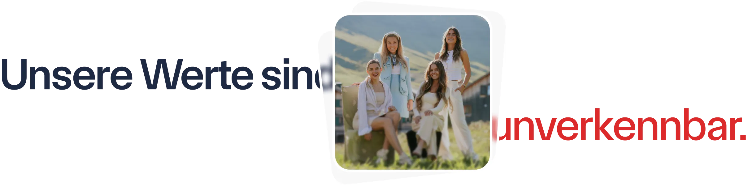 Vier lächelnde Frauen posieren draußen vor einer Berglandschaft bei sonnigem Wetter.