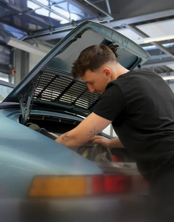 Handwerker schleift Holz, es fliegen Holzspäne durch die Luft.