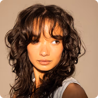 Squared photo of a young, brunette, asian model with a white dress on.