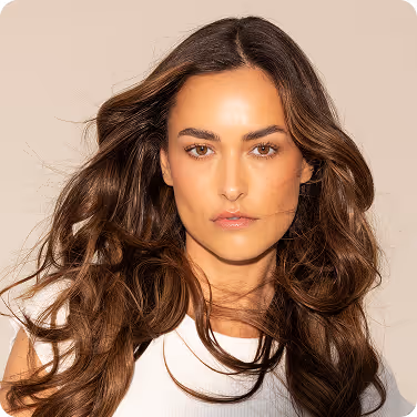 Squared photo of a young, brunette model with a white top on.