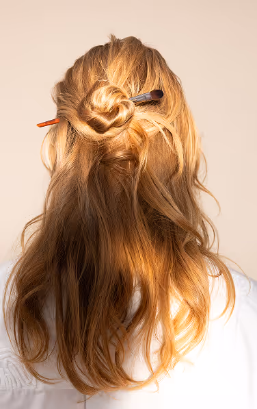Backside photo of a young, blonde model with a white blouse on.