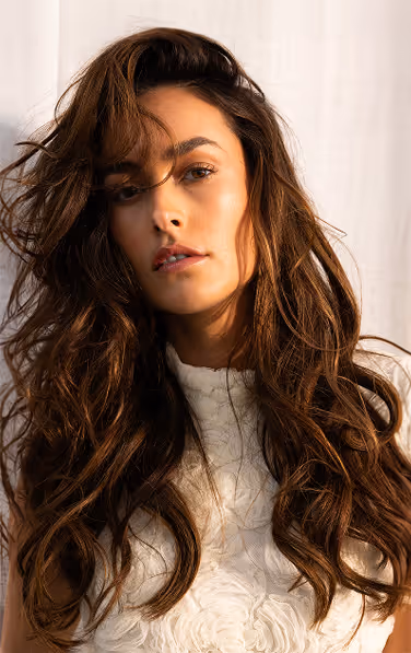 Tall photo of a young, brunette model with a white top on.