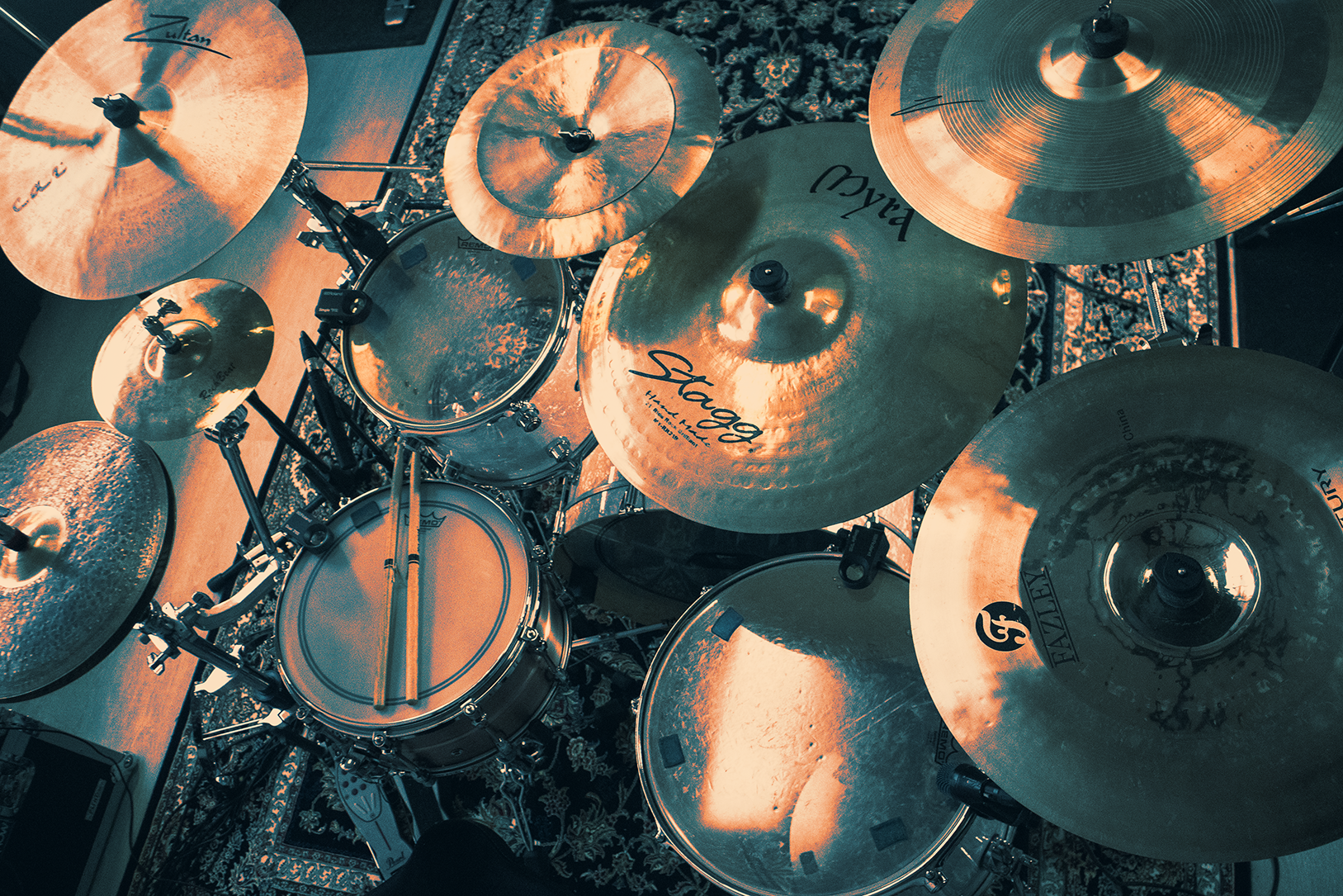Top-down view of a drum kit with multiple cymbals and two drumsticks resting on the snare drum.