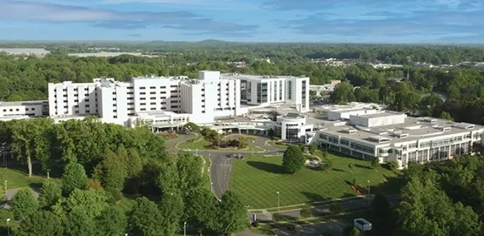 Aerial view of CaroMont Regional Medical Center with a view of tress and hills in the background.