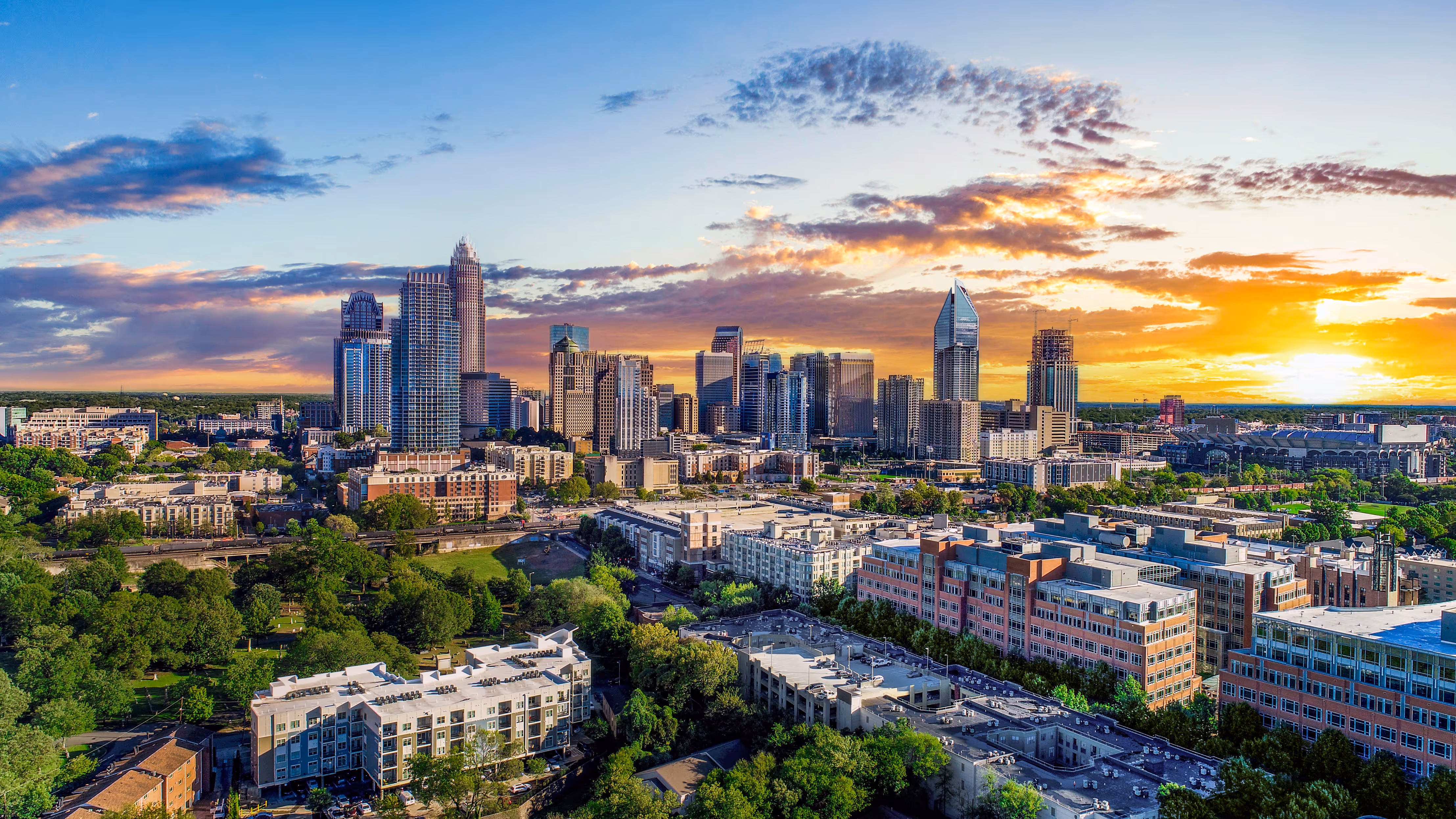 The Charlotte skyline taken at sunset with skyscrapers being shown.