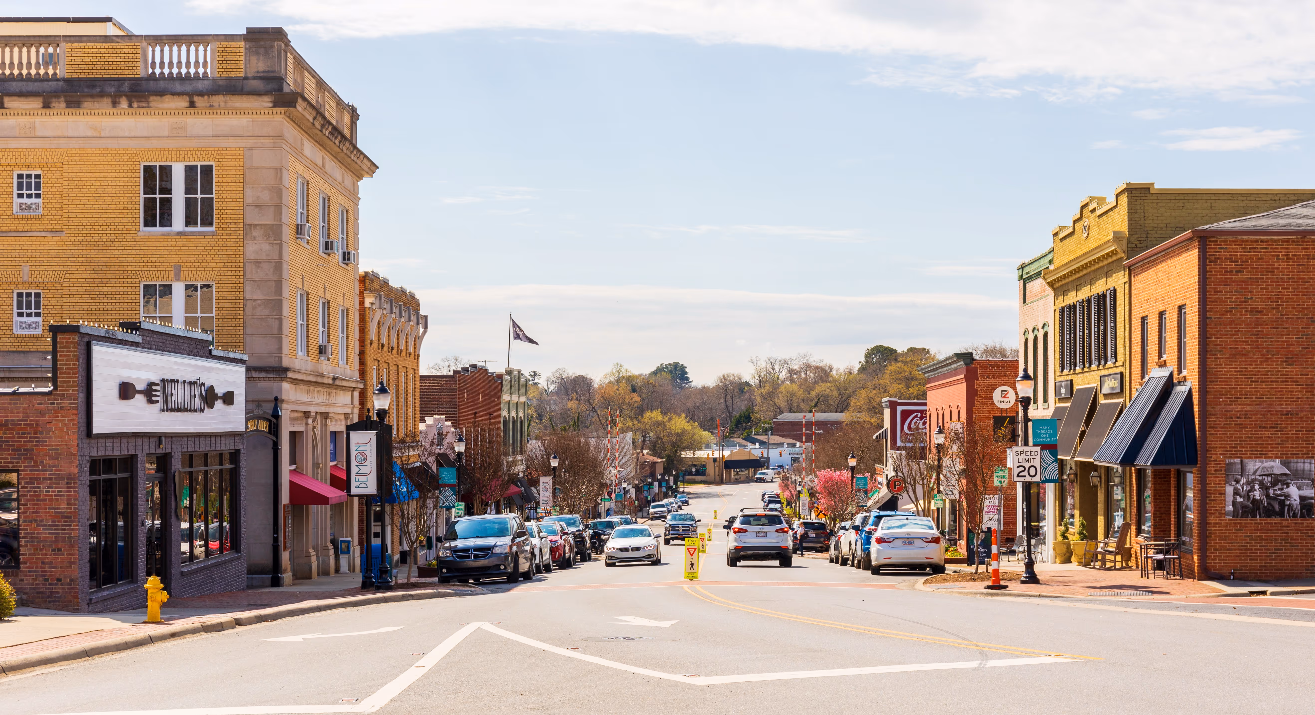 A picture of Belmont, NC downtown showing main street with buildings on both sides of the street and cars driviing down the middle of the road.