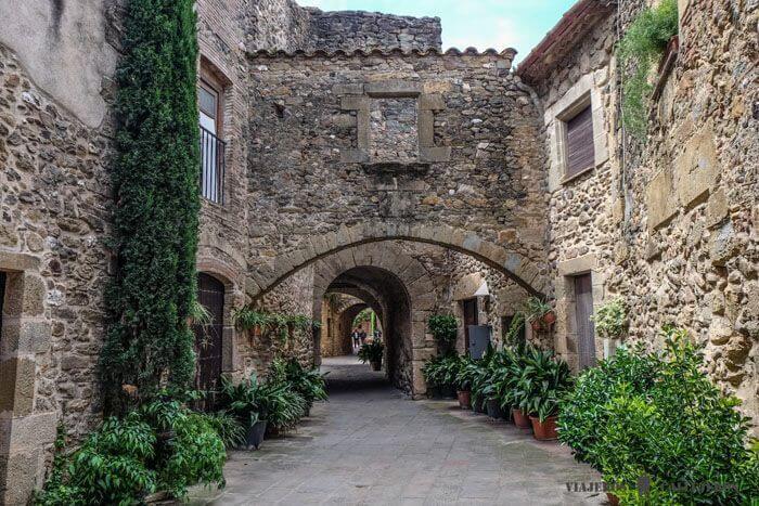Image 17: rue pavée de Monells avec ses maisons en pierres