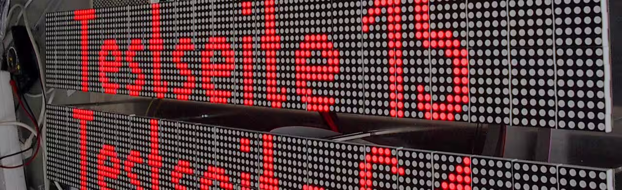 Close-up of two LED matrix modules with red scrolling text and visible cabling